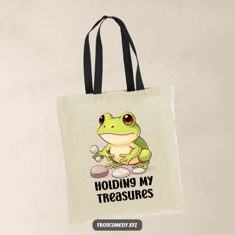 Funny tote bag displaying a determined kawaii frog skillfully juggling three shiny pebbles, symbolizing focus and humorous multitasking abilities.
